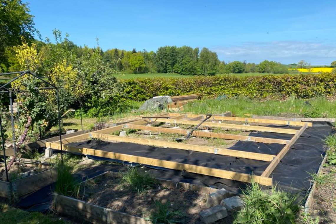 Fundament til drivhuset lægges